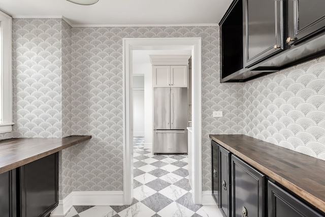 kitchen featuring crown molding, high quality fridge, and wooden counters