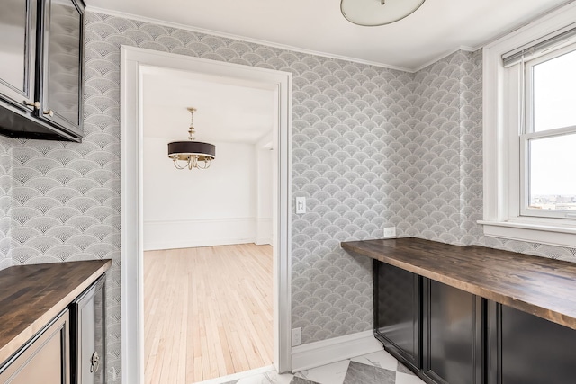 interior space featuring plenty of natural light, wood-type flooring, and crown molding