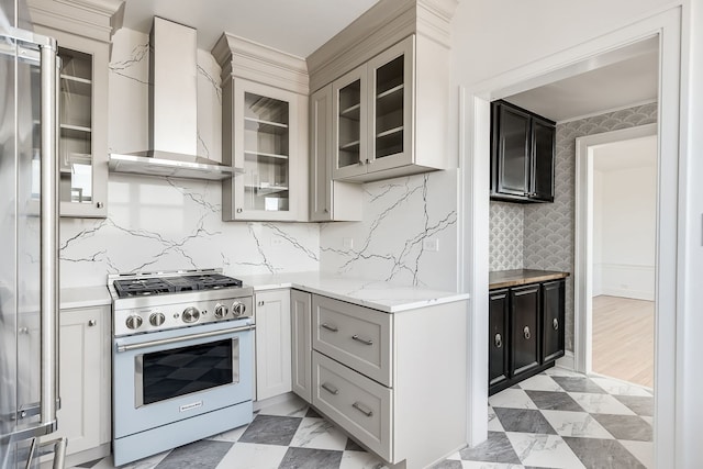 kitchen featuring wall chimney exhaust hood, gray cabinets, high end stainless steel range, and tasteful backsplash