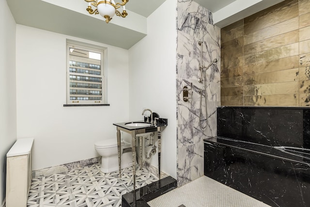 bathroom with a shower, sink, a notable chandelier, and toilet