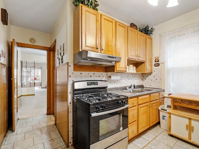 kitchen with backsplash, gas range, sink, and light brown cabinetry