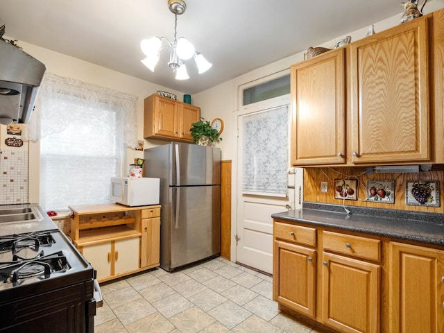 kitchen with pendant lighting, decorative backsplash, stainless steel appliances, and an inviting chandelier