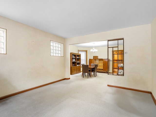 unfurnished room with carpet and a chandelier