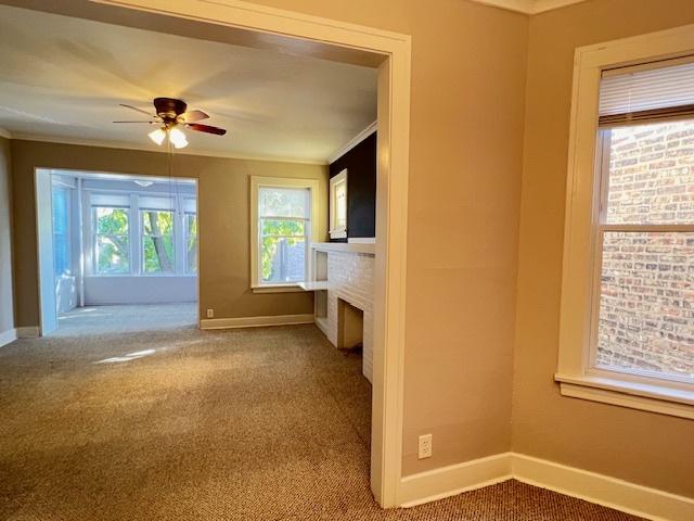 unfurnished living room featuring carpet, ceiling fan, and ornamental molding