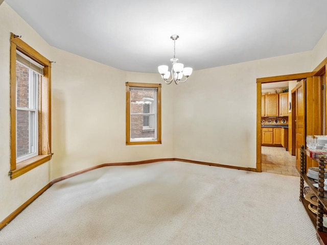 unfurnished room with light carpet and a notable chandelier