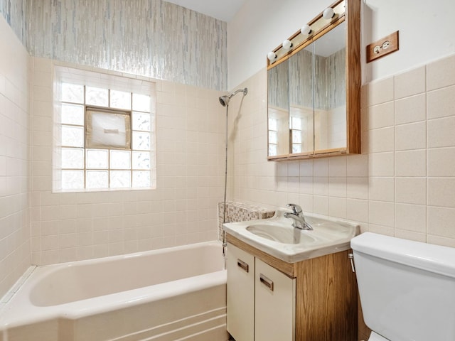 full bathroom with vanity, a healthy amount of sunlight, tile walls, toilet, and tiled shower / bath