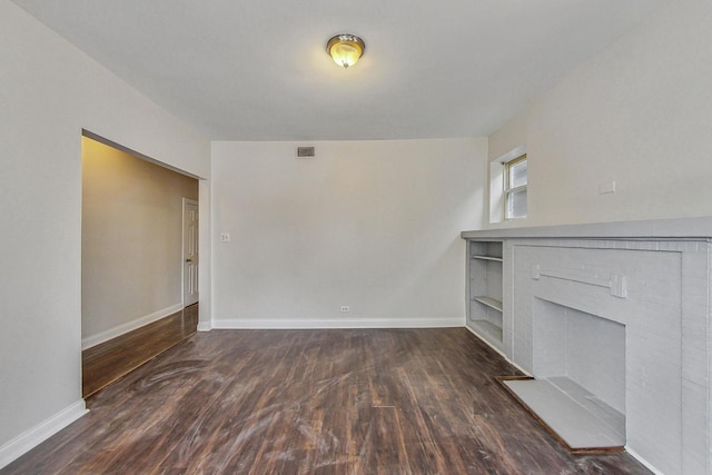 unfurnished living room with dark hardwood / wood-style flooring