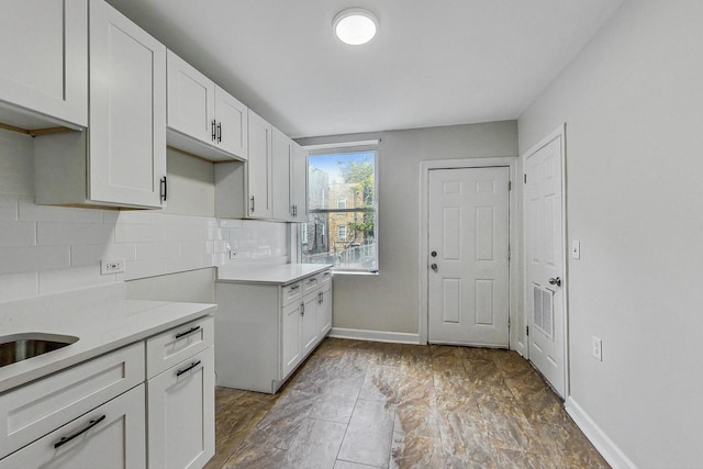 kitchen featuring tasteful backsplash and white cabinetry