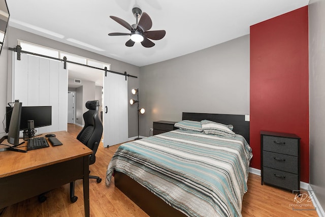 1111 S Wabash Ave Unit 808, Chicago, IL 60605 - bedroom with ceiling fan, a barn door, and light wood-type flooring