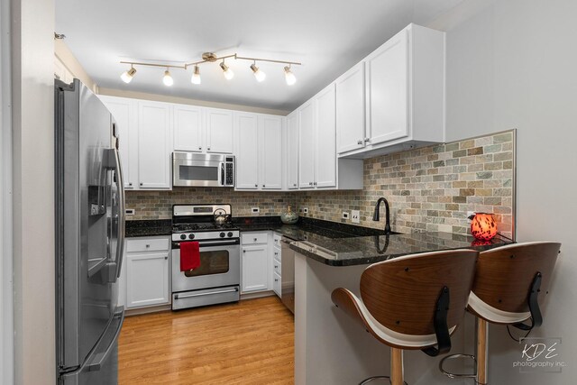 1111 S Wabash Ave Unit 808, Chicago, IL 60605 - kitchen with kitchen peninsula, appliances with stainless steel finishes, tasteful backsplash, dark stone countertops, and white cabinets