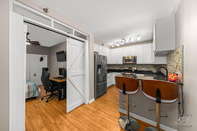 1111 S Wabash Ave Unit 808, Chicago, IL 60605 - kitchen with appliances with stainless steel finishes, backsplash, light wood-type flooring, sink, and white cabinets