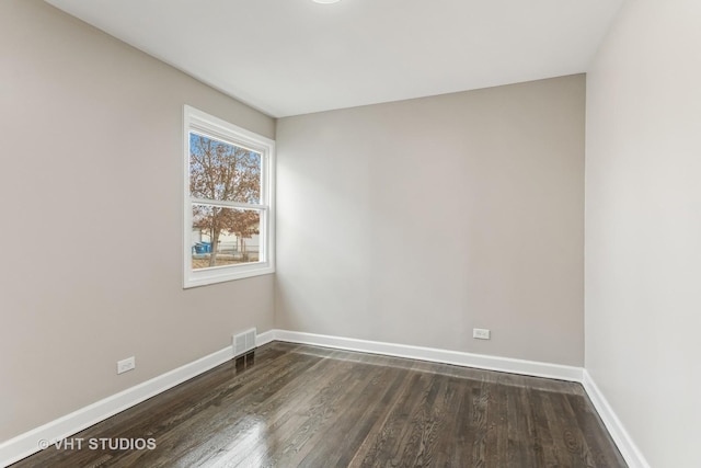 empty room with dark hardwood / wood-style flooring