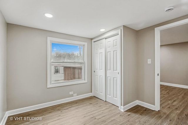 unfurnished bedroom featuring light hardwood / wood-style floors and a closet