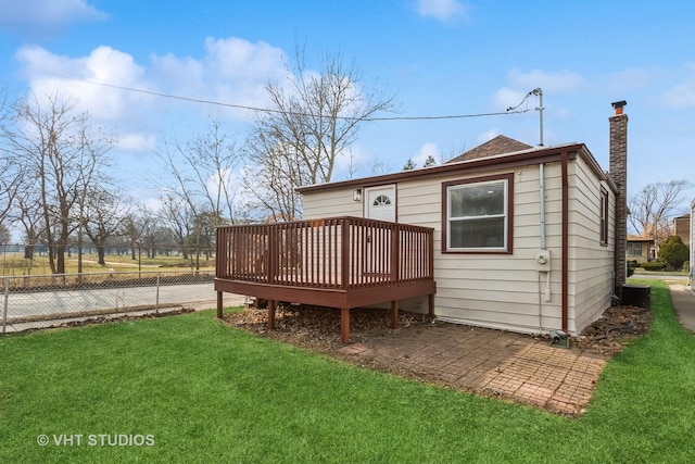 rear view of house with a deck and a lawn