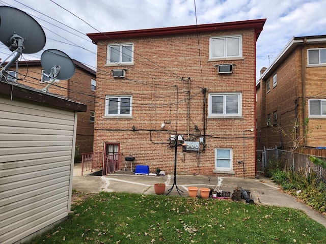 back of property with a yard and a patio