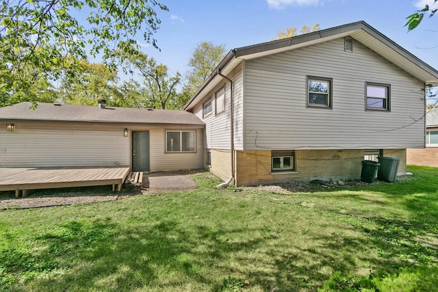 rear view of house with a yard and a wooden deck