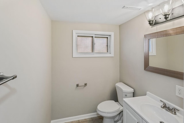 bathroom featuring tile patterned flooring, vanity, a healthy amount of sunlight, and toilet