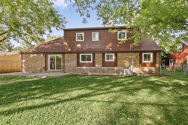 rear view of property featuring a lawn, cooling unit, and a patio area