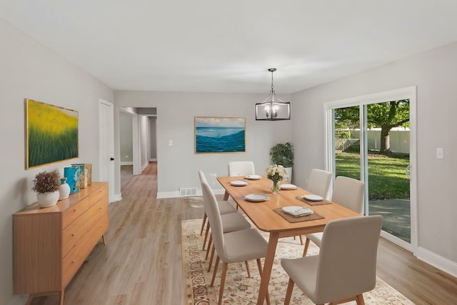 dining area with an inviting chandelier and light wood-type flooring