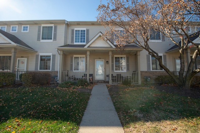 townhome / multi-family property with covered porch and a front lawn