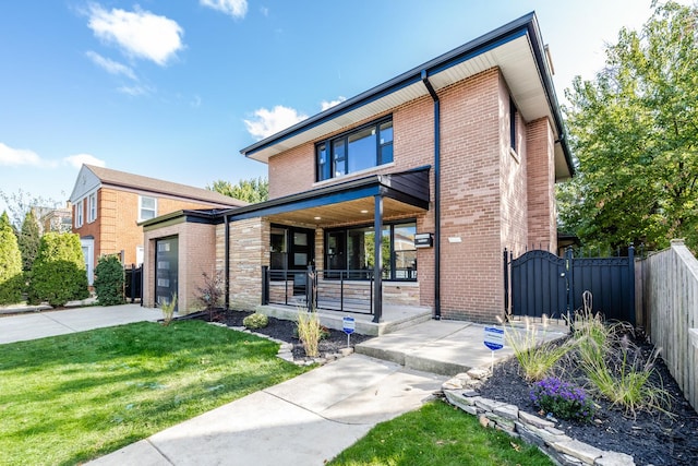 modern home featuring a front lawn, covered porch, and a garage