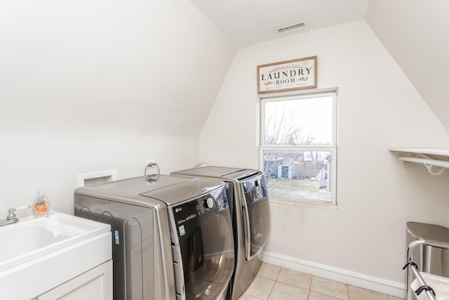 laundry area featuring sink, separate washer and dryer, and light tile patterned flooring