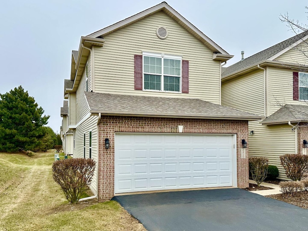 view of property featuring a front lawn and a garage