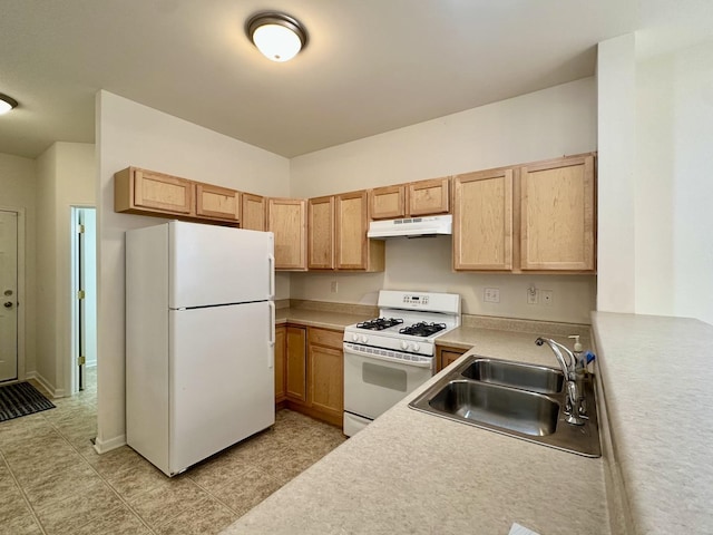 kitchen with light brown cabinetry, white appliances, and sink