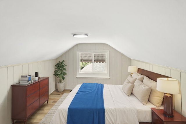 bedroom featuring lofted ceiling and light hardwood / wood-style flooring