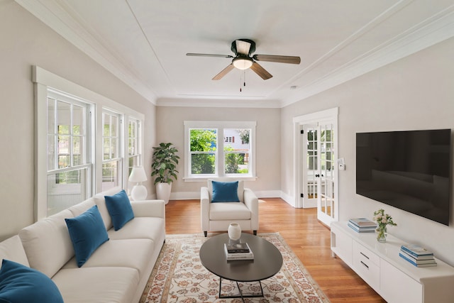 living room with ceiling fan, light hardwood / wood-style floors, ornamental molding, and french doors