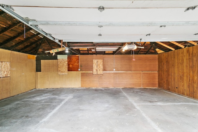 garage with wood walls and a garage door opener