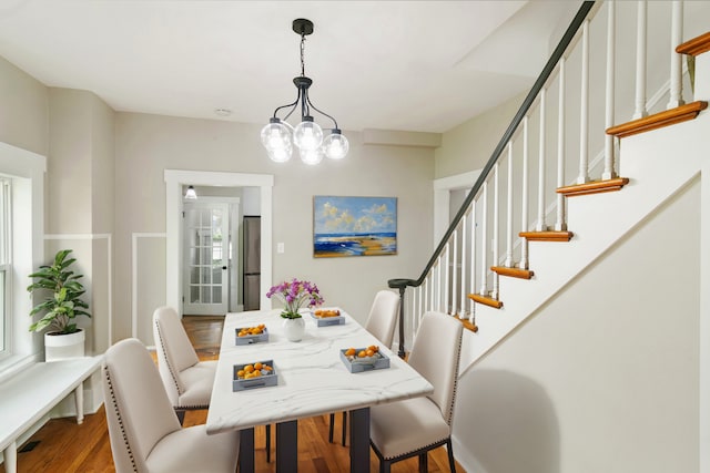 dining area with hardwood / wood-style flooring and a chandelier