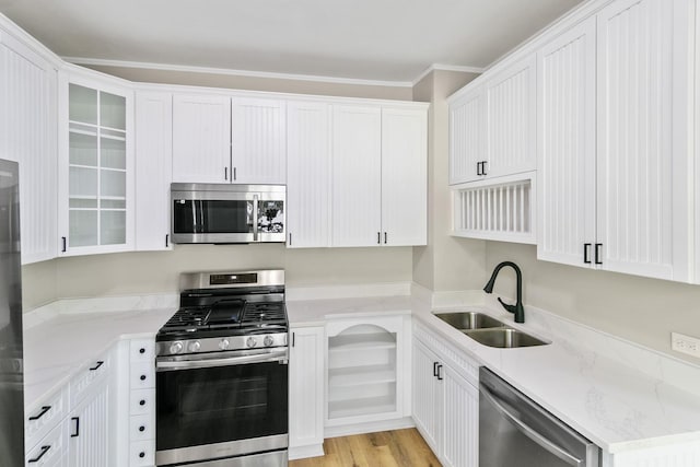 kitchen with light stone counters, white cabinetry, sink, and appliances with stainless steel finishes