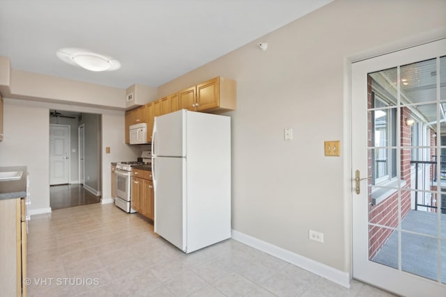 kitchen with white appliances and light brown cabinetry