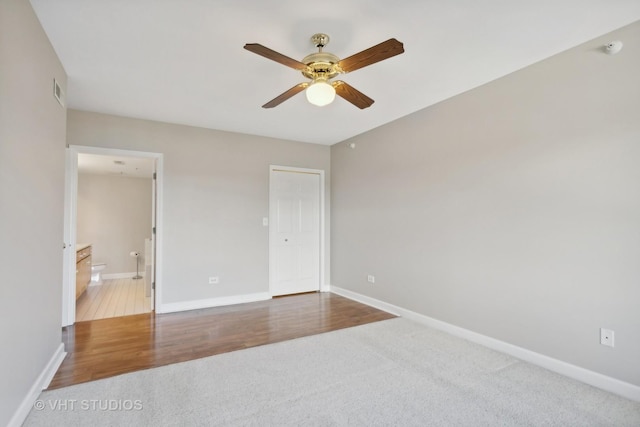 unfurnished bedroom featuring hardwood / wood-style flooring, ceiling fan, a closet, and ensuite bath