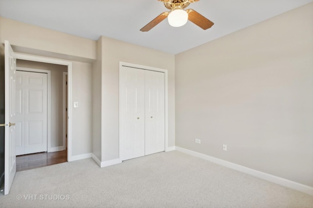 unfurnished bedroom with ceiling fan, light carpet, and a closet