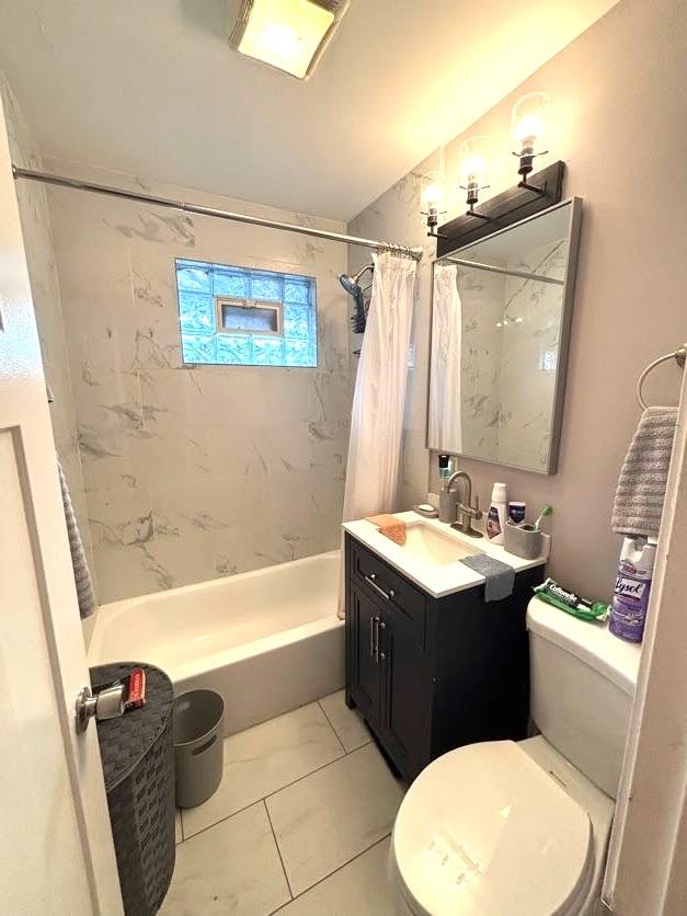 full bathroom featuring toilet, vanity, tile patterned floors, and shower / bathtub combination with curtain