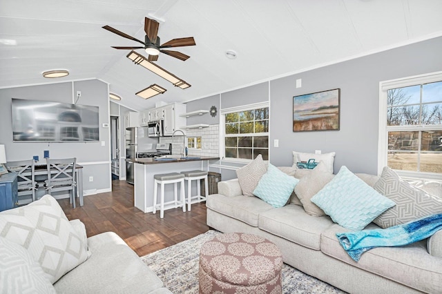 living room with dark hardwood / wood-style flooring, vaulted ceiling, ceiling fan, and sink