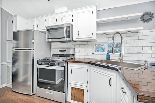 kitchen featuring wood-type flooring, white cabinetry, sink, and appliances with stainless steel finishes