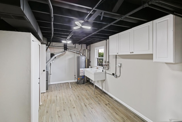 basement featuring light hardwood / wood-style floors, sink, and water heater