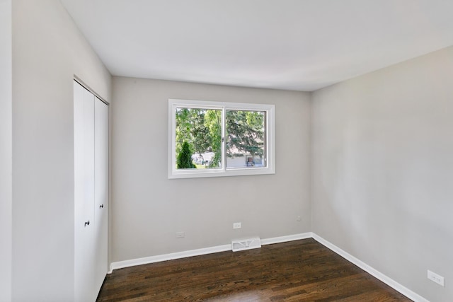 unfurnished bedroom featuring a closet and dark hardwood / wood-style floors