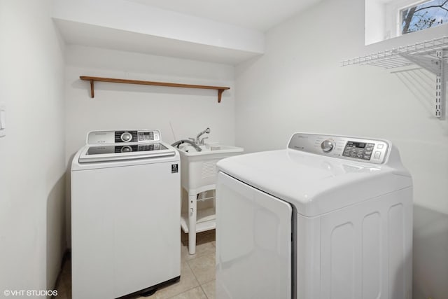 laundry area with washing machine and dryer and light tile patterned floors