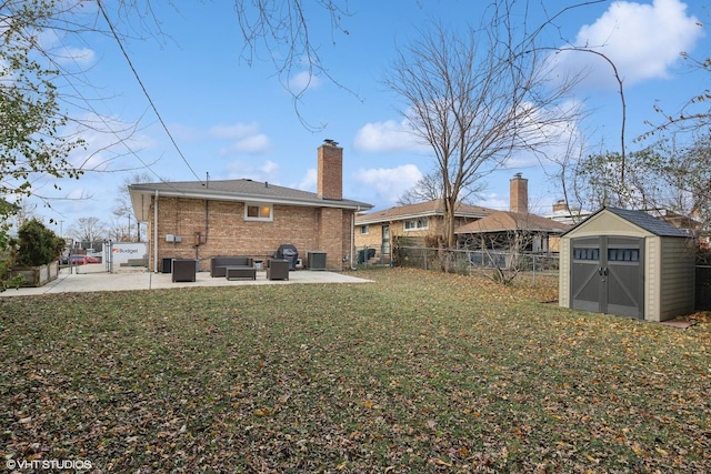 back of property with a lawn, a storage unit, cooling unit, and a patio area