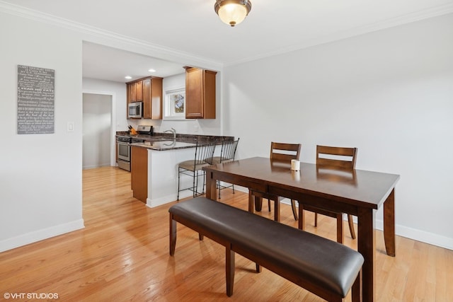 dining space featuring light hardwood / wood-style flooring and ornamental molding