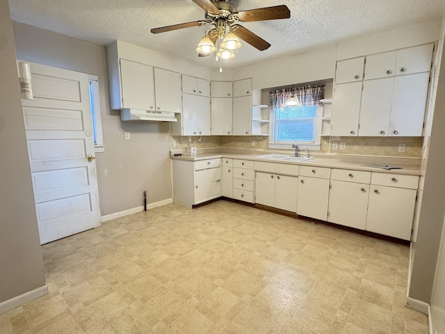 kitchen with white cabinetry, sink, and a textured ceiling