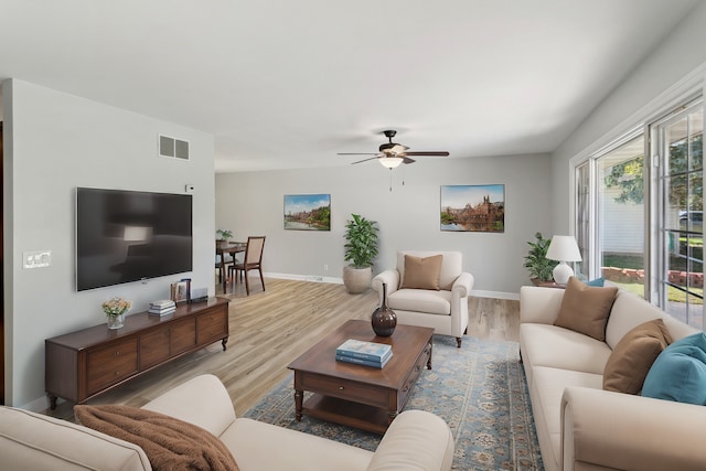 living room featuring ceiling fan and light hardwood / wood-style floors