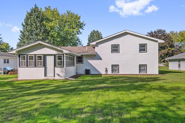 rear view of house featuring a yard and central AC unit