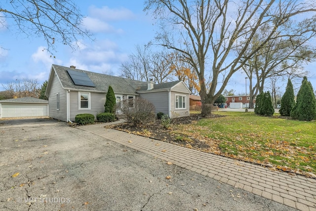 single story home featuring a front yard and solar panels