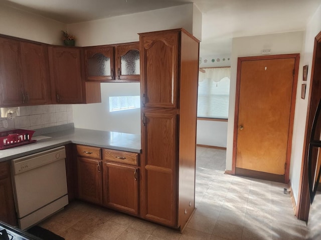 kitchen with white dishwasher and tasteful backsplash