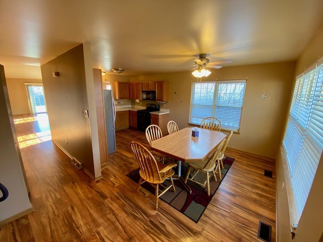 dining area with ceiling fan and wood-type flooring